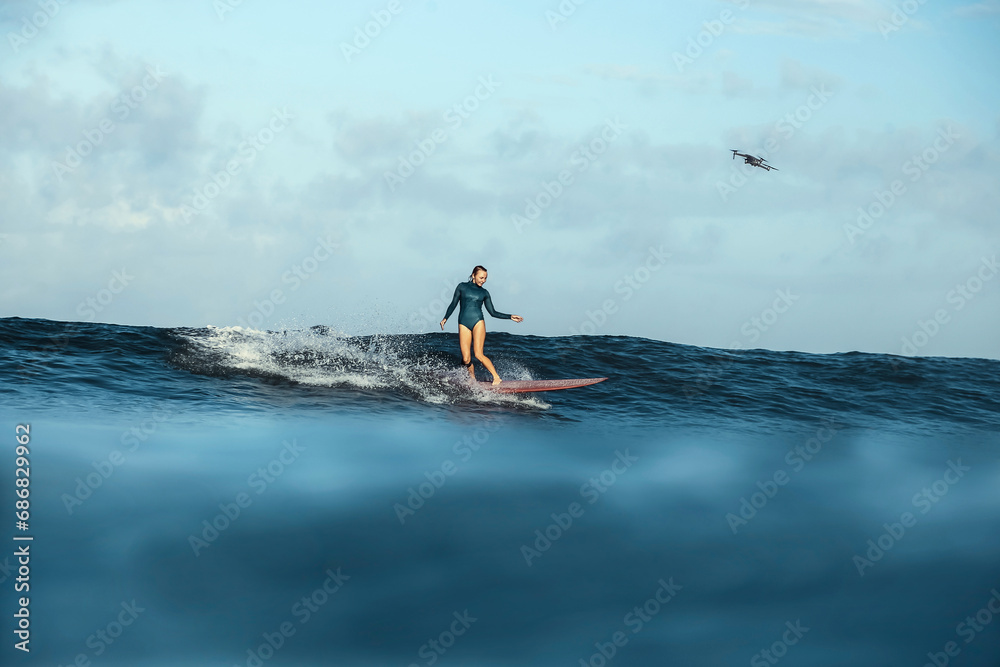 Female Surfer and drone, Bali, Indonesia