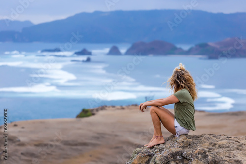 Indonesia, Lombok, woman sitting at the coast looking at view