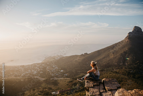 South Africa, Cape Town, Kloof Nek, woman sitting on rock at sunset © tunedin