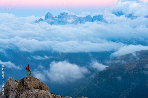 Italy, Veneto, Dolomites, Alta Via Bepi Zac, mountaineer standing on Pale di San Martino mountain at sunset photo