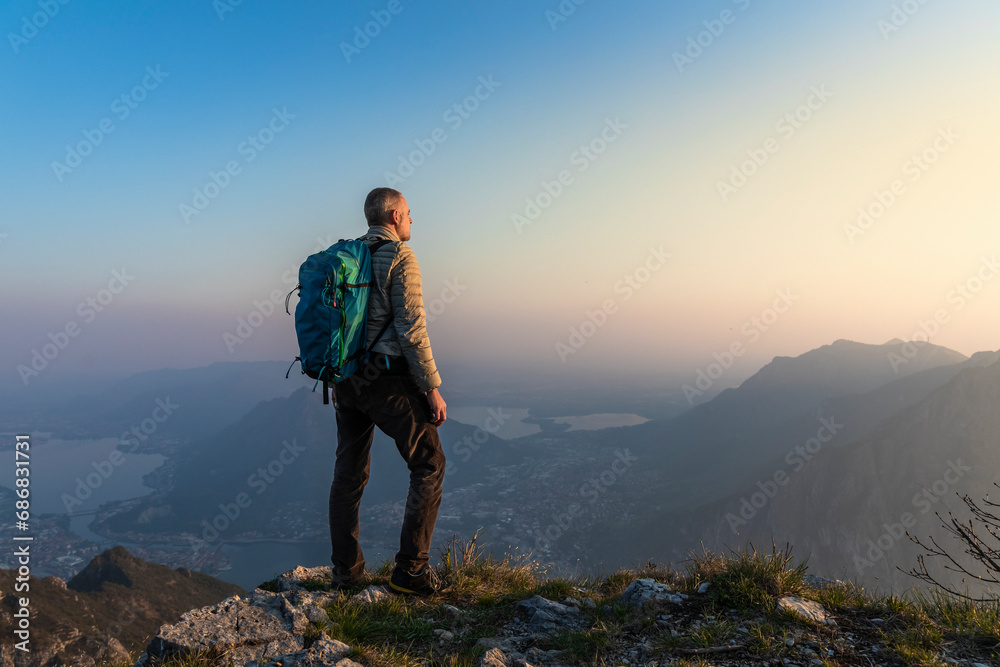 Rear view of hiker on mountaintop, Orobie Alps, Lecco, Italy
