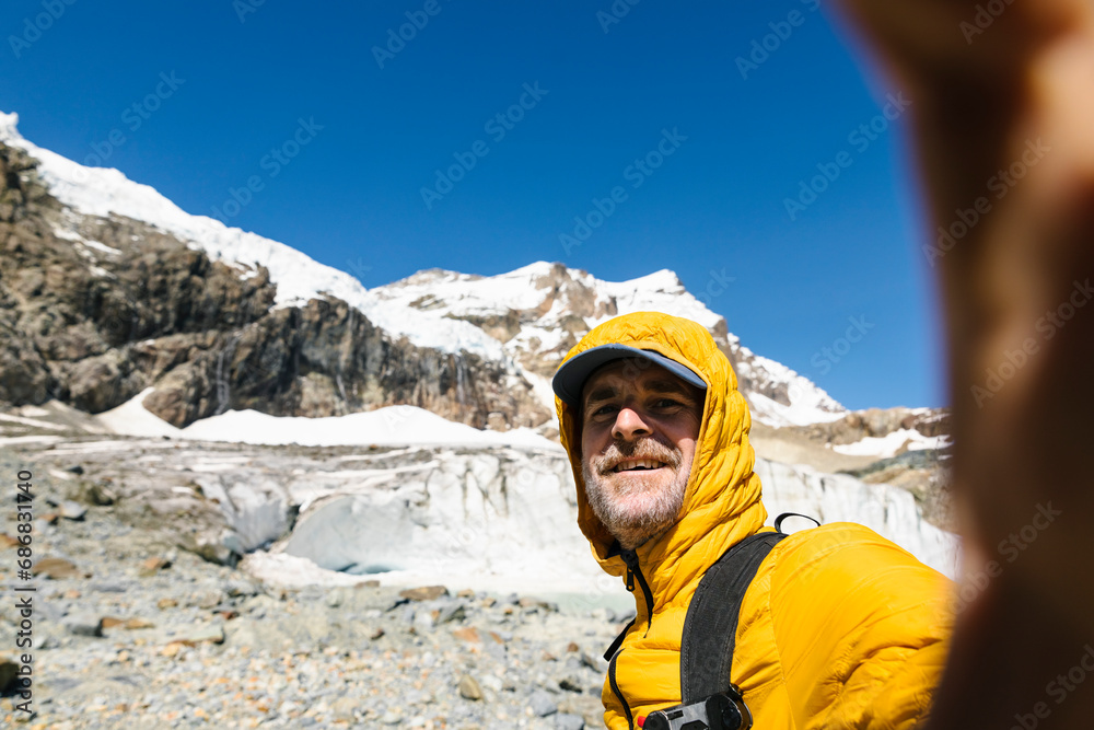 Smiling man taking selfie against snowcapped mountain Smiling man taking selfie against snowcapped mountain