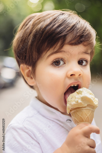 Portrait of toddler eating vanilla ice cream in park