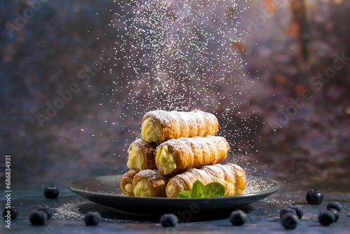 Delicious puff pastry tubes filled with custard. Powdered Sugar photo