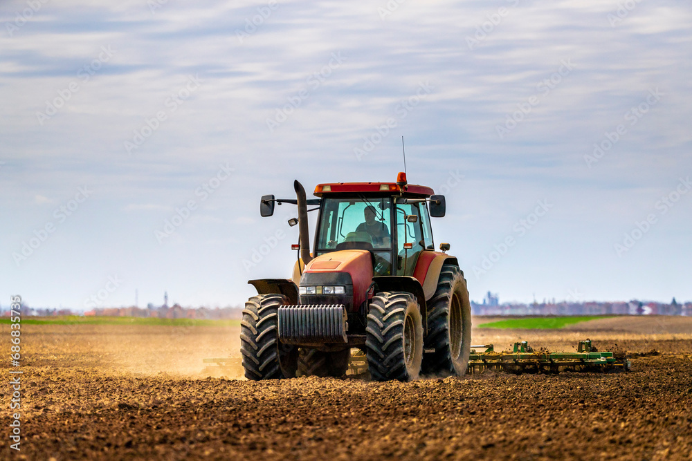 Farmer in tractor plowing field in spring Farmer in tractor plowing field in spring