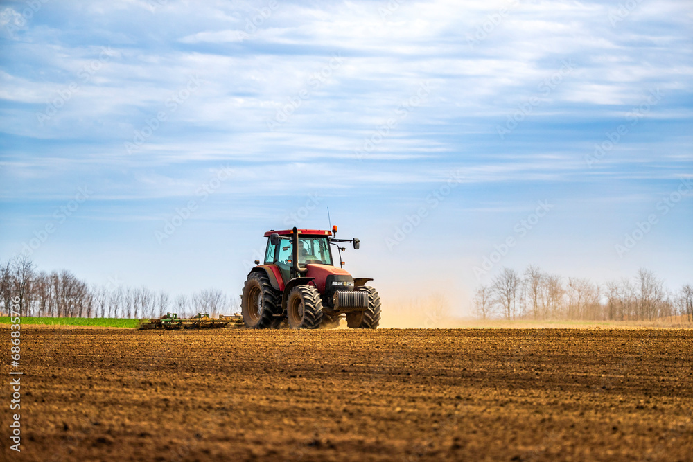 Farmer in tractor plowing field in spring Farmer in tractor plowing field in spring