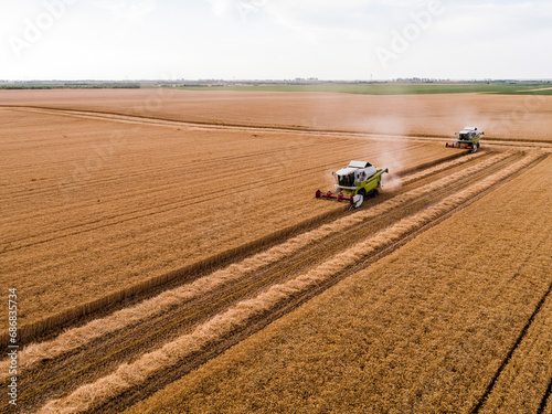 Serbia, Vojvodina. Combine harvester on a field of wheat, aerial view photo