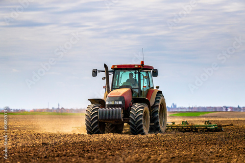 Farmer in tractor plowing field in spring © tunedin