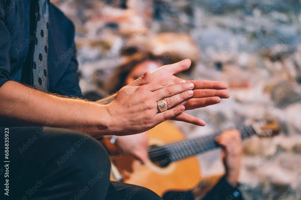 Close-up of singer clapping hands while man playing guitar in club - obrazy, fototapety, plakaty 
