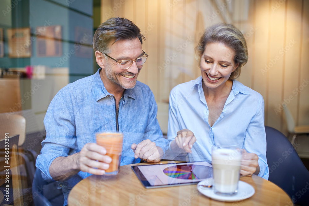 Happy woman and man using tablet in a cafe Happy woman and man using tablet in a cafe