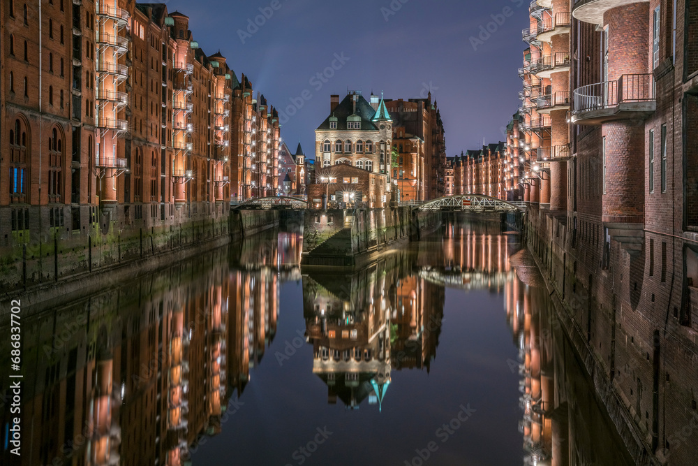 Germany, Hamburg, Speicherstadt, lighted old buildings with Elbe Philharmonic Hall in the background