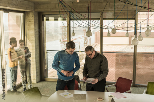 Business man showing document to colleague in office