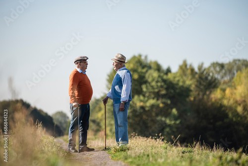 Two old friends standing in the fields, talking about old times