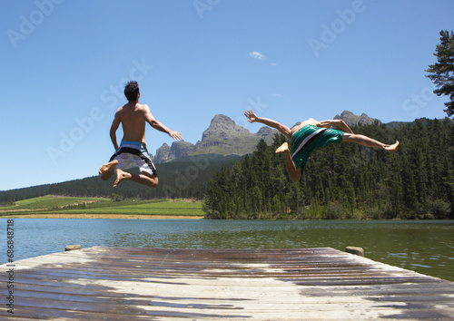 Men Jumping into Water from Dock photo