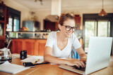 Happy Young Woman Working on Laptop at Home