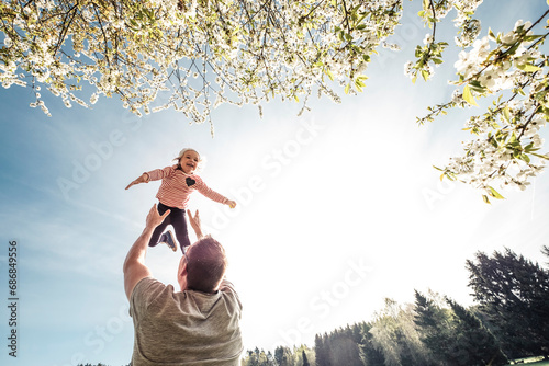 Father throwing little daughter in air