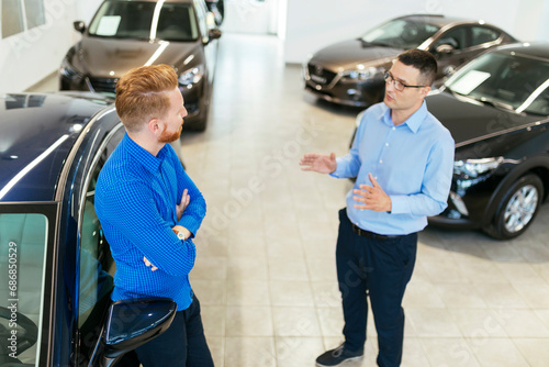 Salesman advising customer in car dealership