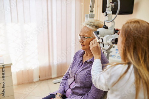 ENT physician examining ear of a senior woman