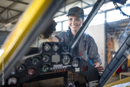 Mechanic in hangar cleaning windscreen of light aircraft