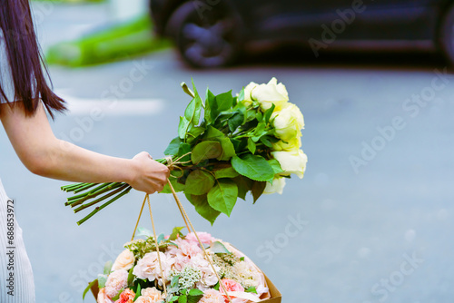 Girl carrying two bouquets of flowers to the car