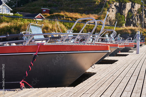 Aluminium fishing boats for sport fishing in the public pier in the norwegian willage in the fjord. Sport fishing is a part of culture in Scandinavia and popular outdoor all year activity in Norway.