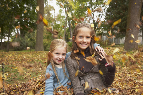 Portrait of Girls Sitting in Autumn Leaves photo