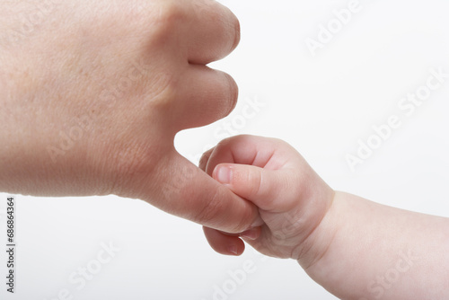 Baby's Hand Holding Adult's Finger photo