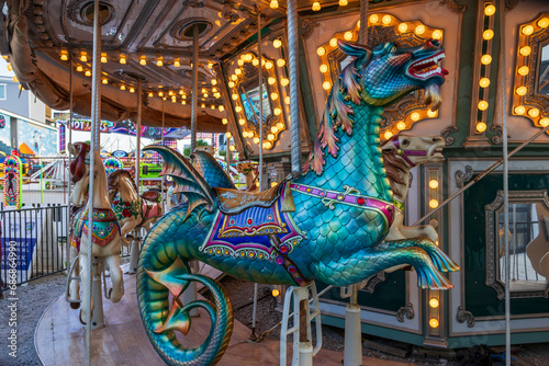 A Merry-go-round with horses and seahorses with colorful lights and carnival rides along the boardwalk at the Carolina Beach Boardwalk in Carolina Beach North Carolina USA