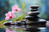 a stack or pyramid of stones, bamboo and an orchid in the water. balancing pebble stone. concept of relaxation, equilibrium.