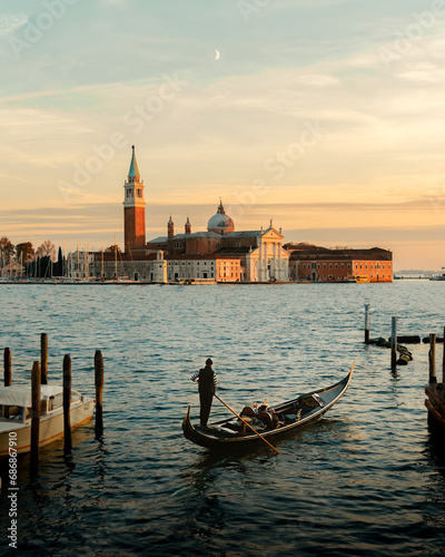 venezia venice Italy city. Small boat in the foreground cruising towards the church during clean sunset © Luk