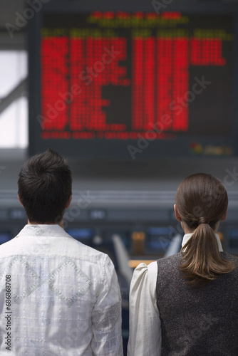 People Looking at Sign in Airport