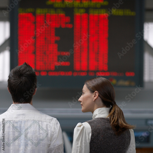 People Looking at Sign in Airport photo