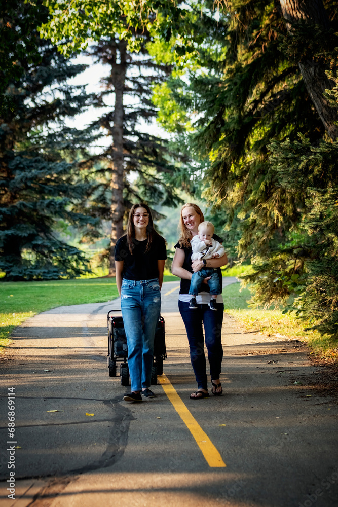 Mother spending quality time with her teenage daughter and young son who has Down Syndrome in a city park during an autumn day; Leduc, Alberta, Canada