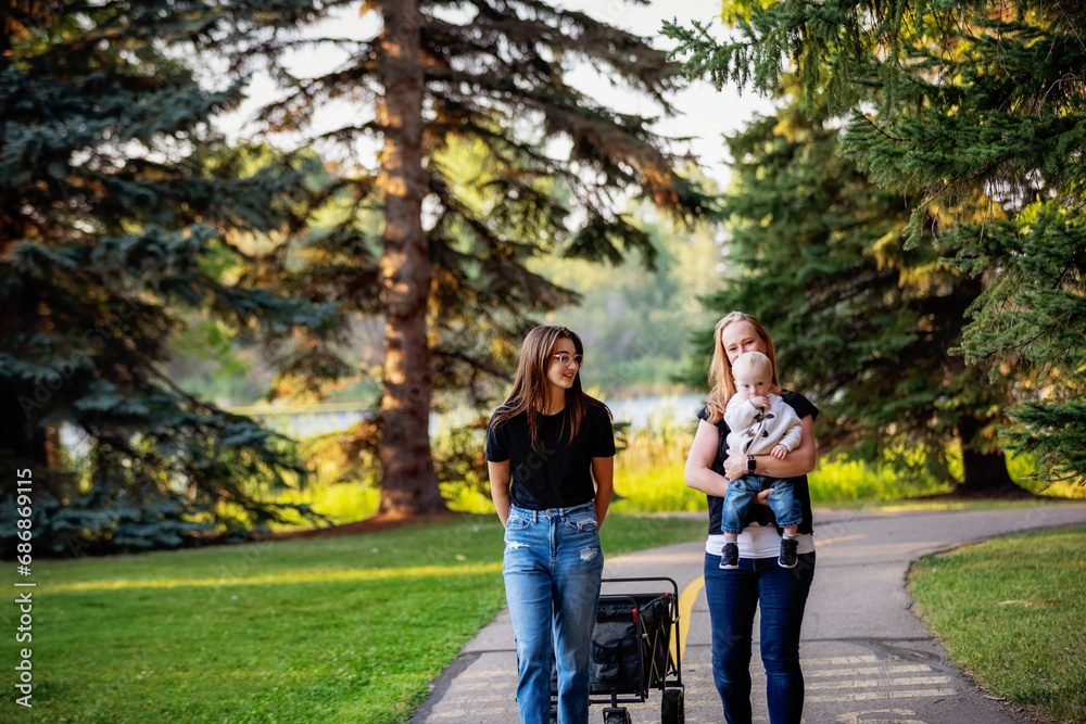 Mother spending quality time with her teenage daughter and young son who has Down Syndrome in a city park during an autumn day; Leduc, Alberta, Canada Mother spending quality time with her teenage daughter and young son who has Down Syndrome in a city park during an autumn day; Leduc, Alberta, Canada