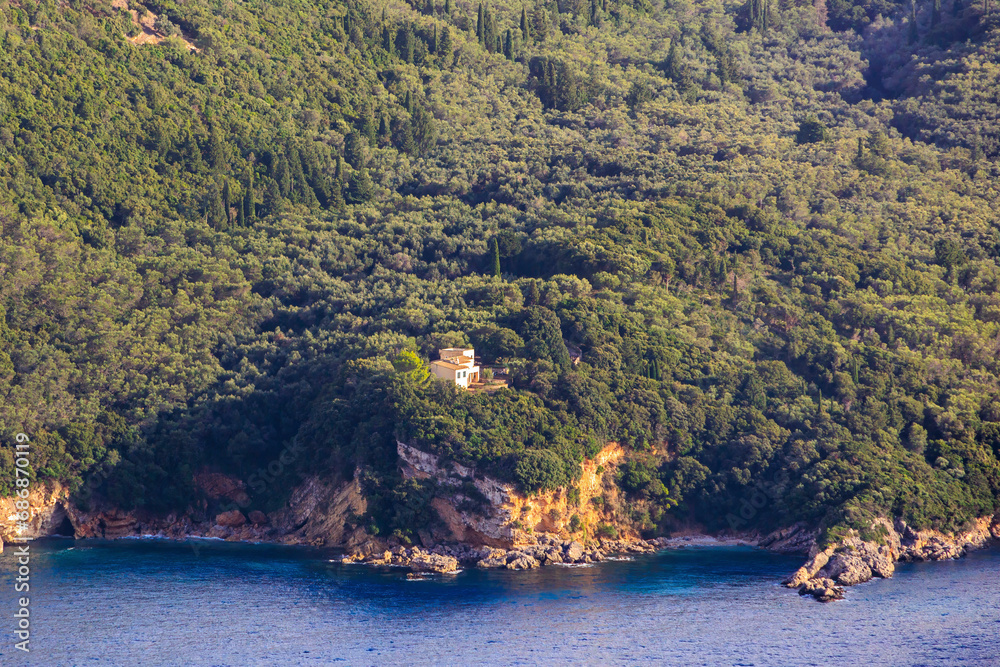 Fototapeta premium View in the evening under a blue sky over the bay and the sea near Paleokastrtitsa on the island of Corfu