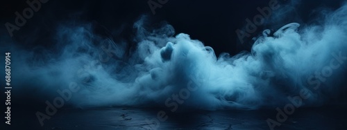 Black stage with blue smoke below, like fog on the floor. In a dark room. photo