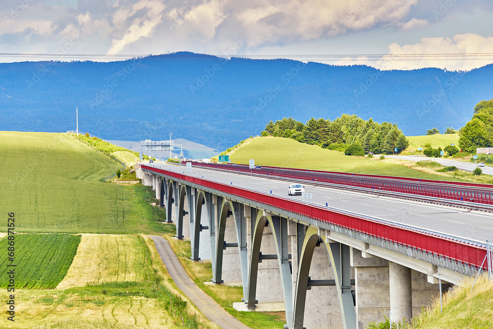 Autostrada highway in Europe. D1 magistal near Spišský hrad, arched bridge. Motorway viaduct bridge, Spis region, Slovakia. Green summer fields, hills of Tatra mountains.