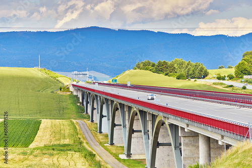 Autostrada highway in Europe. D1 magistal near Spišský hrad, arched bridge. Motorway viaduct bridge, Spis region, Slovakia. Green summer fields, hills of Tatra mountains. photo