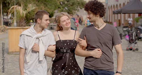 Romantic relationships among three individuals polyamory, involve consensually and openly loving and connecting with multiple partners simultaneously. Girl and two guys posing looking at camera.  photo