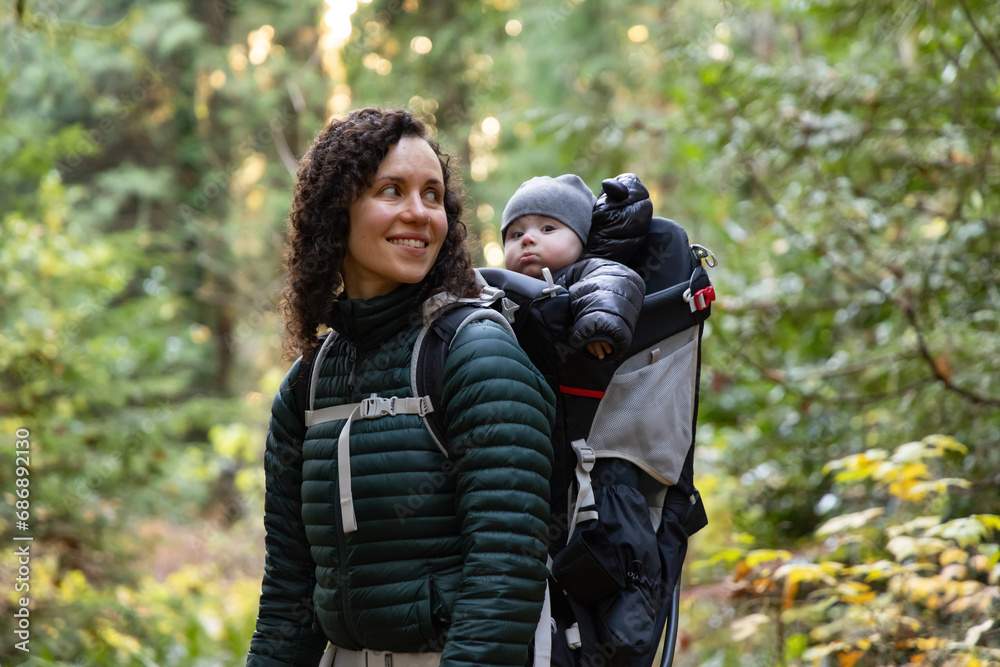 Fototapeta premium Mother Hiking with Baby in Backpack Carrier in Canadian Nature.