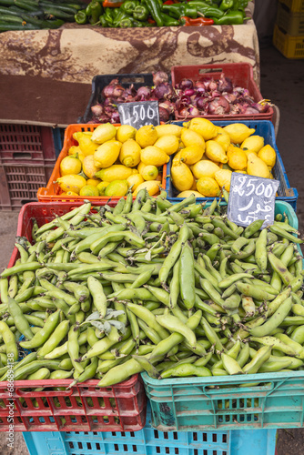 Fresh bean pods, lemons, and red onions for sale at the outdoor souk in Bir al Haffay.