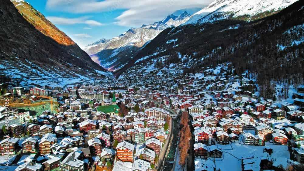 Aerial view of wooden Swiss houses and a Cathedral covered by snow in ...