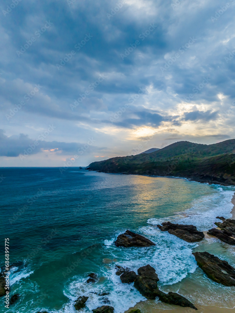 Rain clouds, rocks and sunrise at the seaside Rain clouds, rocks and sunrise at the seaside