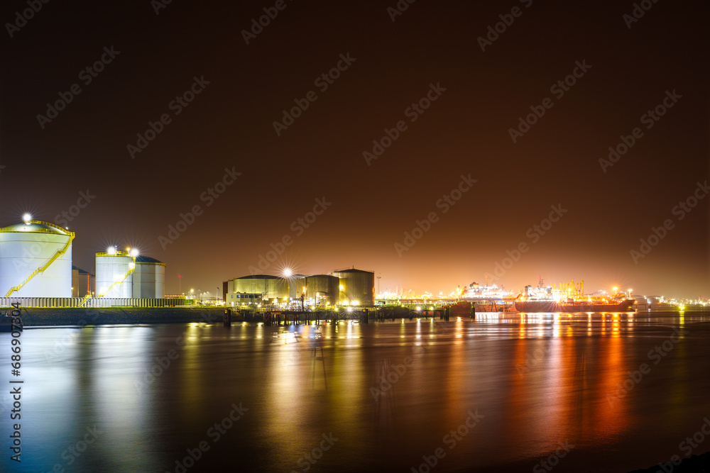 The misty evening view of the Rotterdam Port shows the bustling harbor with glowing night lights casting an enchanting atmosphere over the city's skyline, creating a captivating and atmospheric scene.