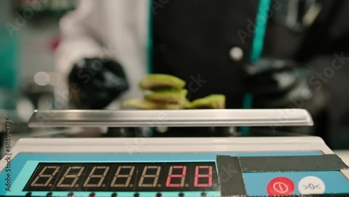 close-up of a chef weighing pieces of avocado on a scale in a restaurant before preparing a dish of sushi rolls photo