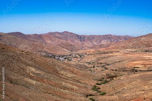 A small town is seen in the desert valley. Photography taken in Fuerteventura, Canary Islands, Spain.