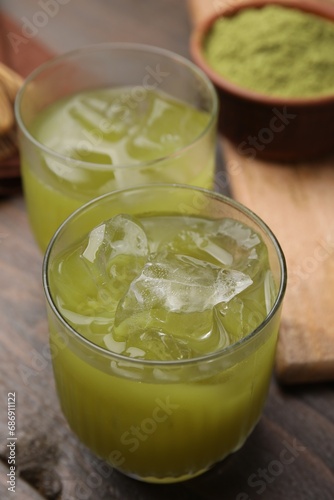 Delicious iced green matcha tea on wooden table, closeup