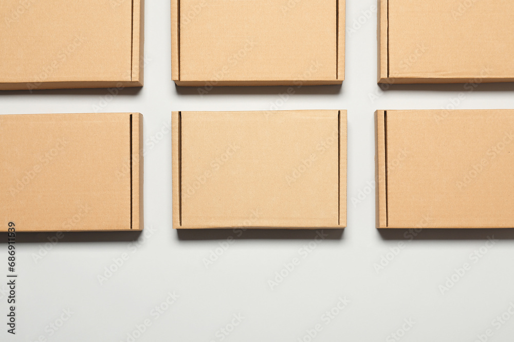 Fototapeta premium Many cardboard boxes on white background, flat lay. Packaging goods