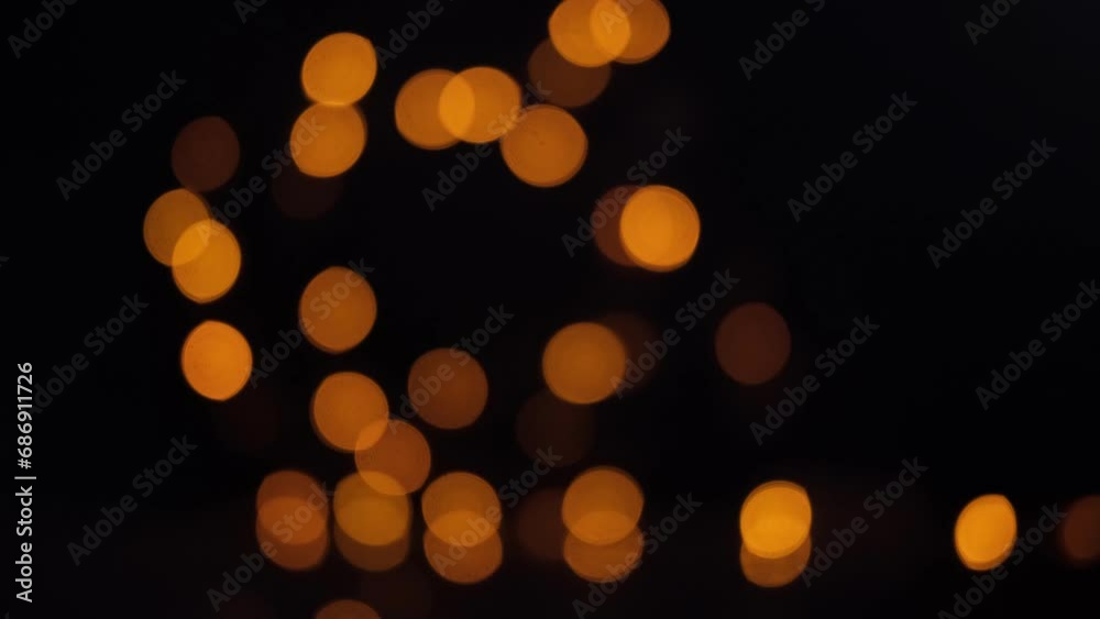 Blinking bokeh lights on isolated black background. Unfocused. Christmas fairy light.