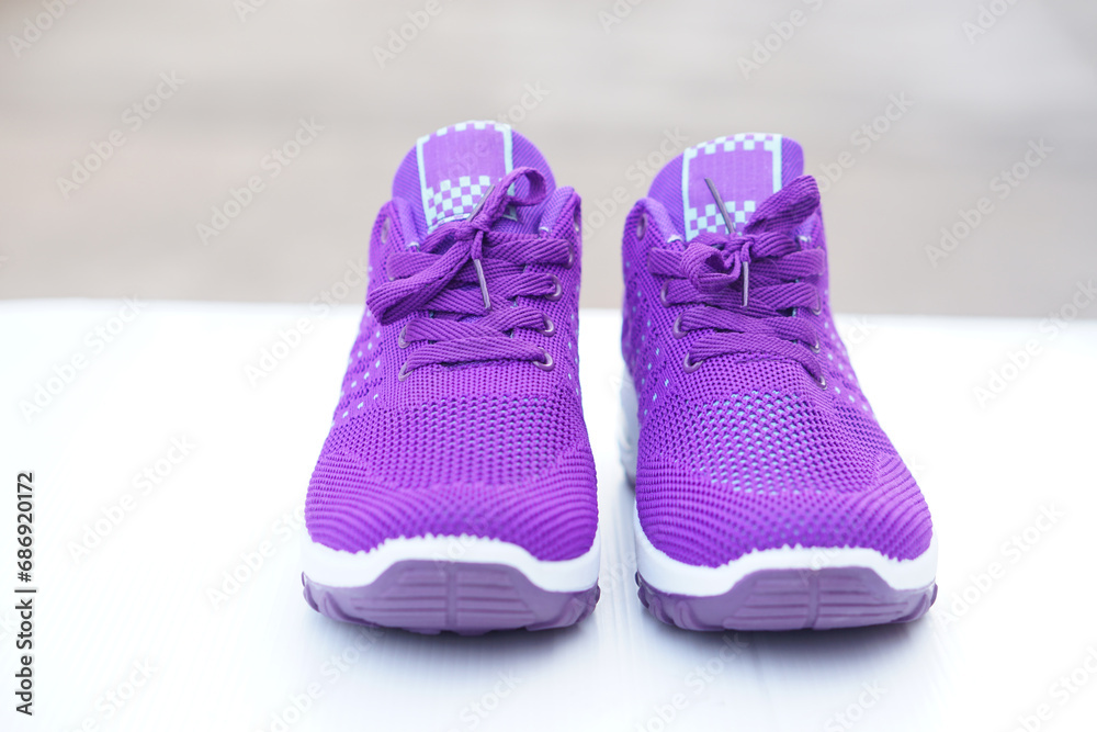 Pair of new purple sneakers. Fashionable and comfortable sport footwears. outdoor background.  Concept, shoes for doing sport or exercise also can wear for traveling, hiking.     